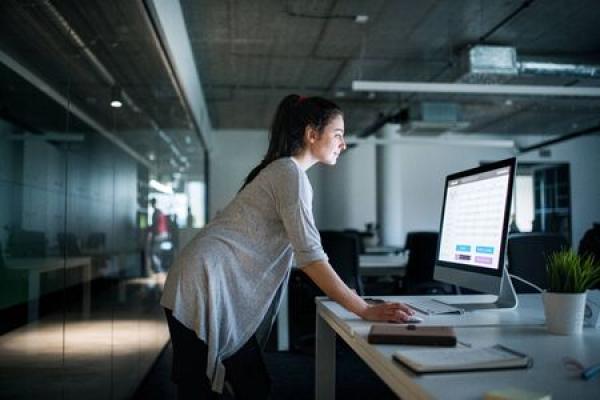 A woman works at a standing desk