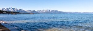 A shoreline view of Lake Tahoe with the Sierra Nevada Mountains in the background