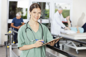 Portrait of confident female physiotherapist holding clipboard and pen in fitness studio of rehab center
