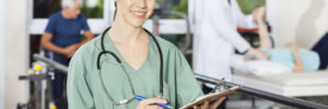Portrait of confident female physiotherapist holding clipboard and pen in fitness studio of rehab center